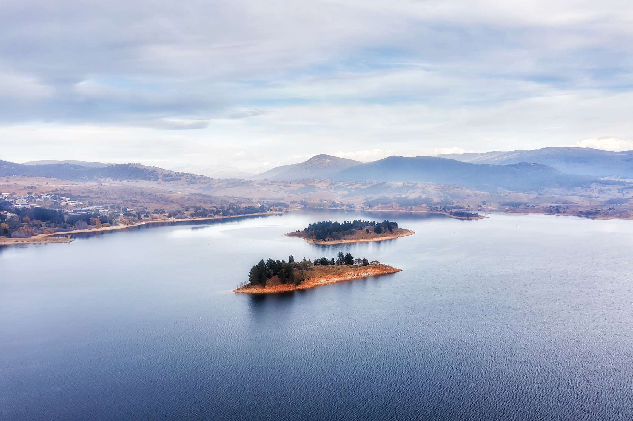 aerial view of a serene lake with a small island in the center