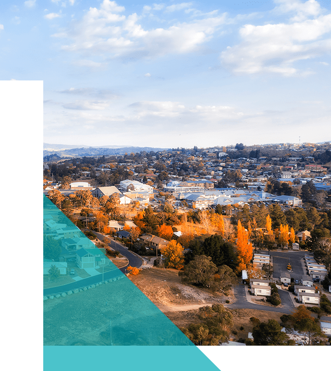 Aerial view of a town with a mix of autumn-colored trees and buildings